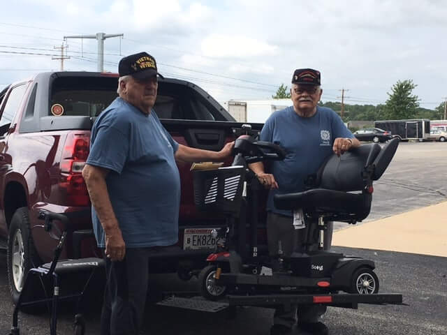 two friends with mobility scooter and motor lift