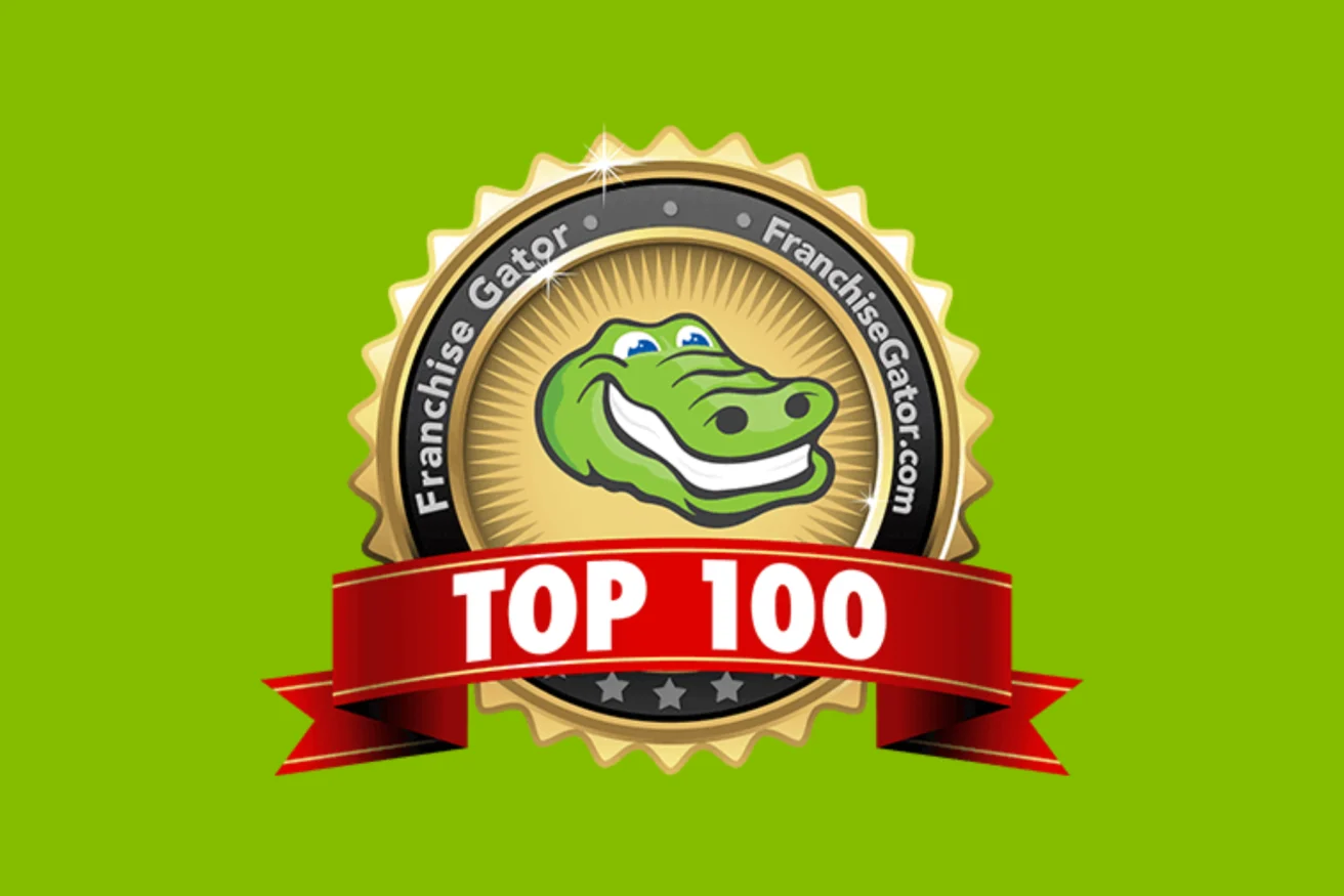 A badge with a smiling alligator and the text "Franchise Gator" encircling it. A red ribbon across the bottom reads "TOP 100." The background is green.