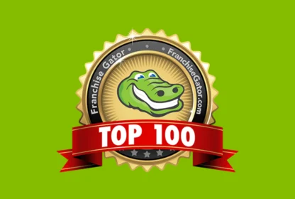 A badge with a smiling alligator and the text "Franchise Gator" encircling it. A red ribbon across the bottom reads "TOP 100." The background is green.