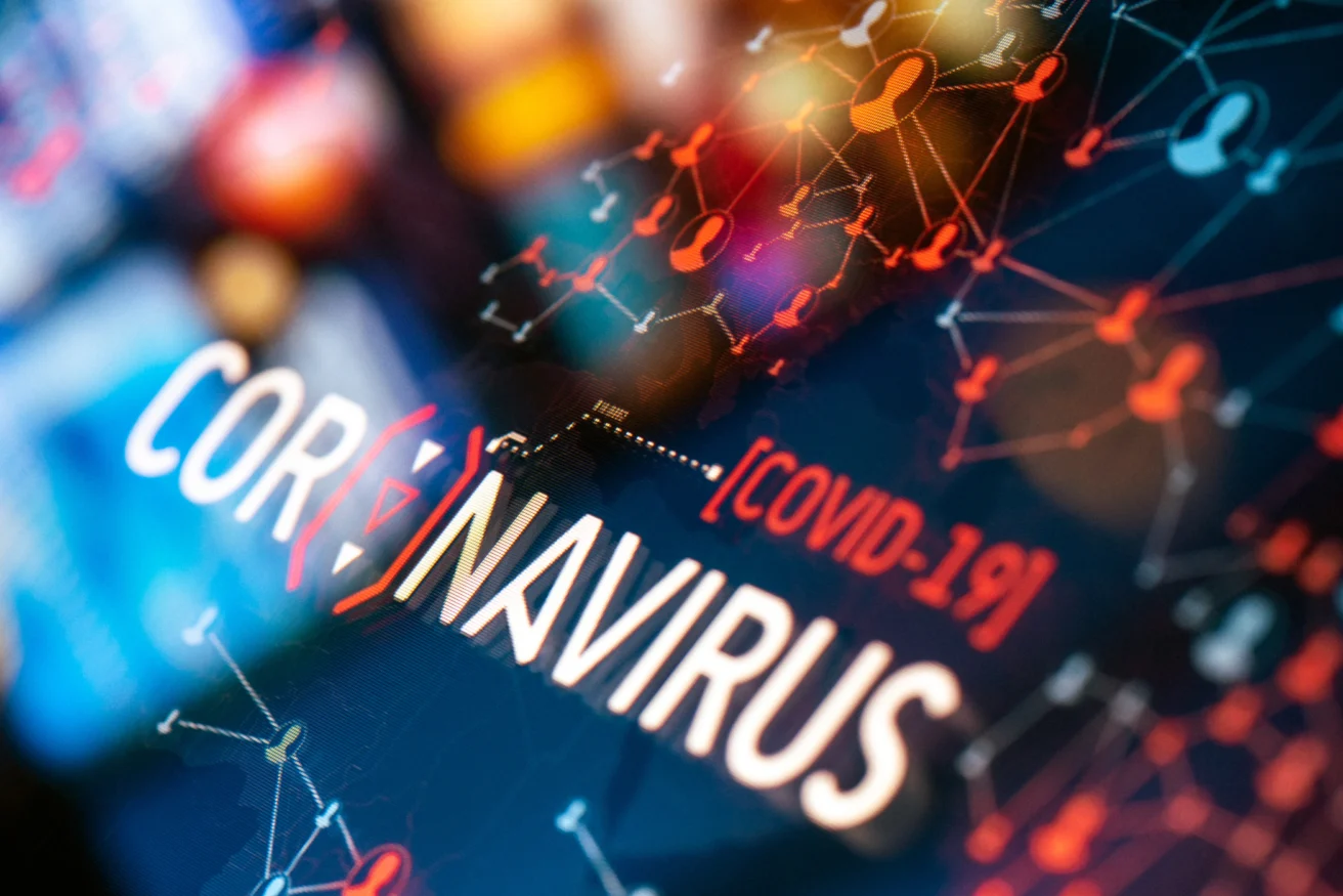 Close-up of a digital display showing the words "Coronavirus" and "COVID-19" with interconnected graphics and nodes.