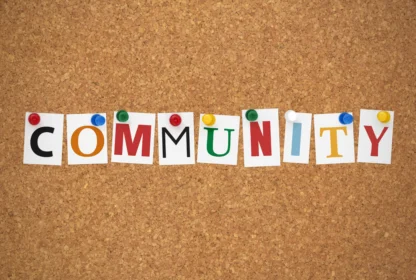 The word "COMMUNITY" is spelled out using colorful letters pinned to a corkboard.