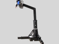 A black robotic arm with a blue motor on a stand, set against a gray background.