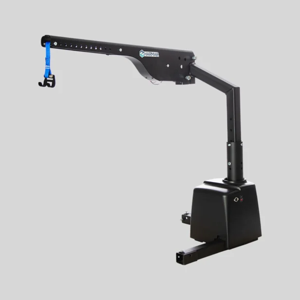 A black mechanical lift with a blue nylon strap and hook attachment for lifting objects, set against a plain gray background.