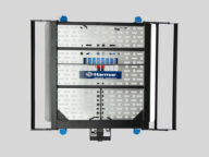 A Harmar vehicle lift platform for wheelchairs, featuring a silver metal surface with star-shaped cutouts and black frames on the sides.