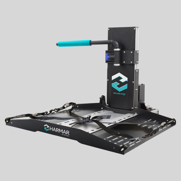 A black, motorized wheelchair lift with a blue handle and straps, branded with "Harmar" and contact information on the vertical section.