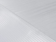Close-up of a textured white surface with diagonal and parallel lines creating a patterned design. The image showcases the fine details and textures of the surface.