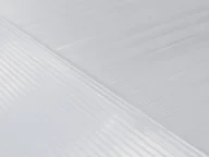 Close-up of a textured white surface with diagonal and parallel lines creating a patterned design. The image showcases the fine details and textures of the surface.