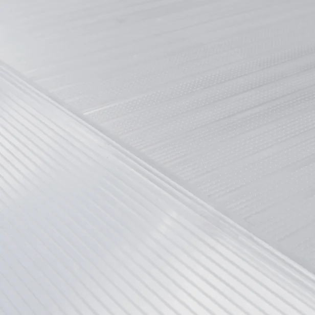 Close-up of a textured white surface with diagonal and parallel lines creating a patterned design. The image showcases the fine details and textures of the surface.