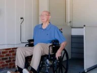 a man on a wheelchair using a Bruno vertical platform lift.