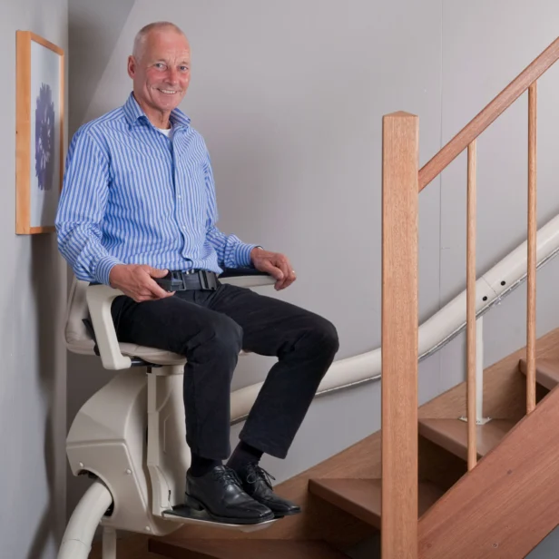 a man using a Handicare Freecurve Curved Stairlift.