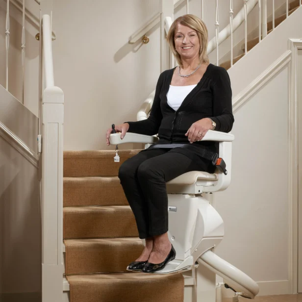 a woman using a Handicare Freecurve Curved Stairlift.