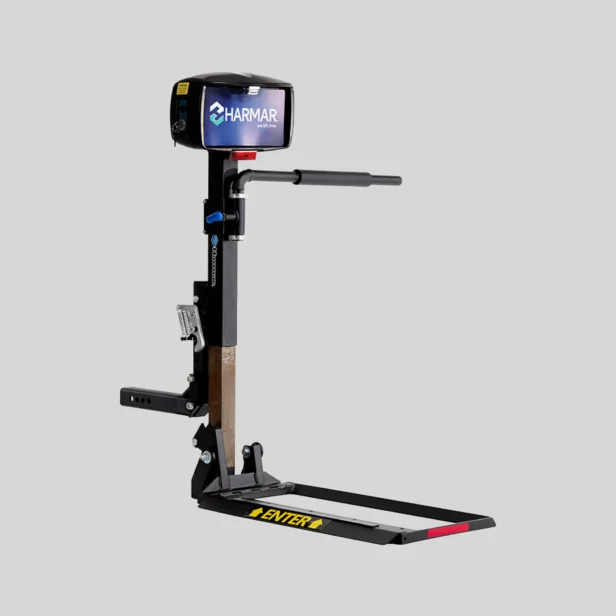 A motorized mobility lift with Harmar branding for transporting wheelchairs or scooters, featuring a platform, control box, and mounting brackets.