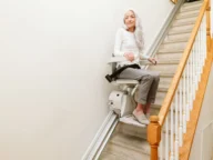 a woman using a bruno elan straight rail stairlift.