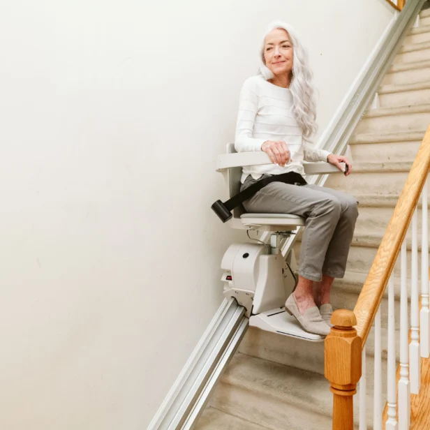 a woman using a bruno elan straight rail stairlift.