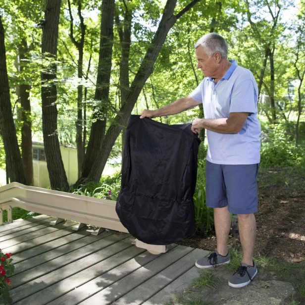 a man covering up a bruno elite outdoor curved stairlift.