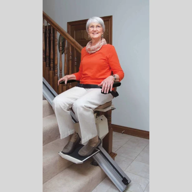 a woman using a staying home indoor stairlift.