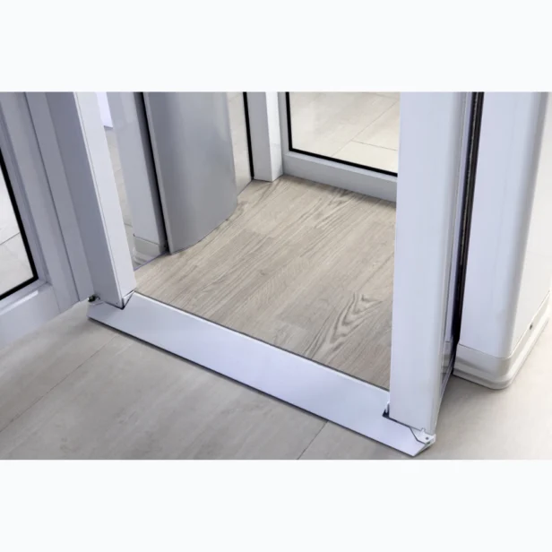 Revolving door with a wooden floor mat and metal frame, positioned on a light tiled floor.