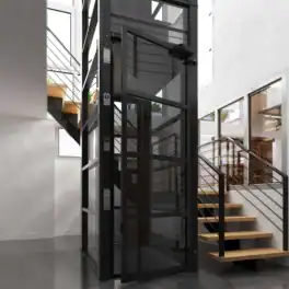 A modern glass home elevator is installed beside a wooden staircase with metal railings in a bright, contemporary interior space.