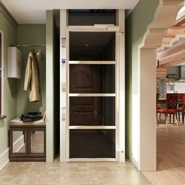 A modern residential elevator with glass doors is installed in a hallway next to a coat rack, bench, and mirror, leading into a dining area.