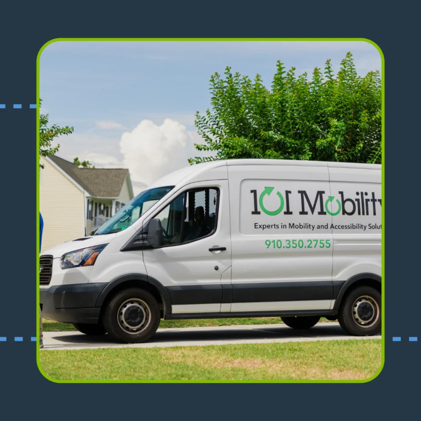 A white van with "101 Mobility" and contact information parked on a residential street, with green shrubs and houses in the background.