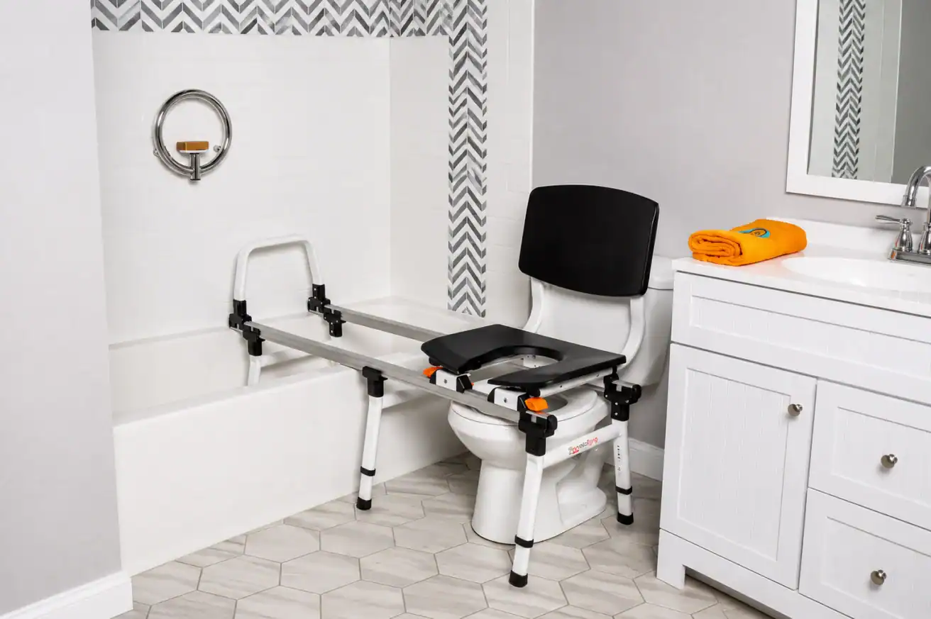 A bathroom features a transfer bench spanning a bathtub and toilet, designed to assist individuals with mobility challenges in safely moving between the two.