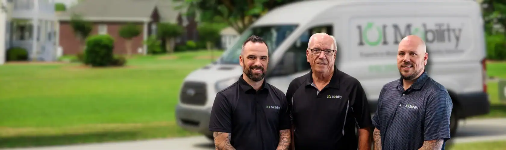Three men stand in front of a blurred van with "TDJ Mobility" branding, outside in a suburban neighborhood.