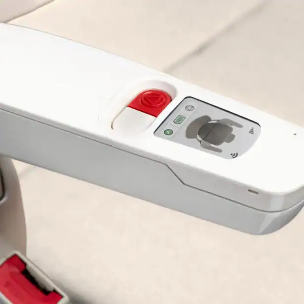 Close-up of a white electric vehicle charging station with a display screen, control buttons, and a slot for connecting a charging cable.