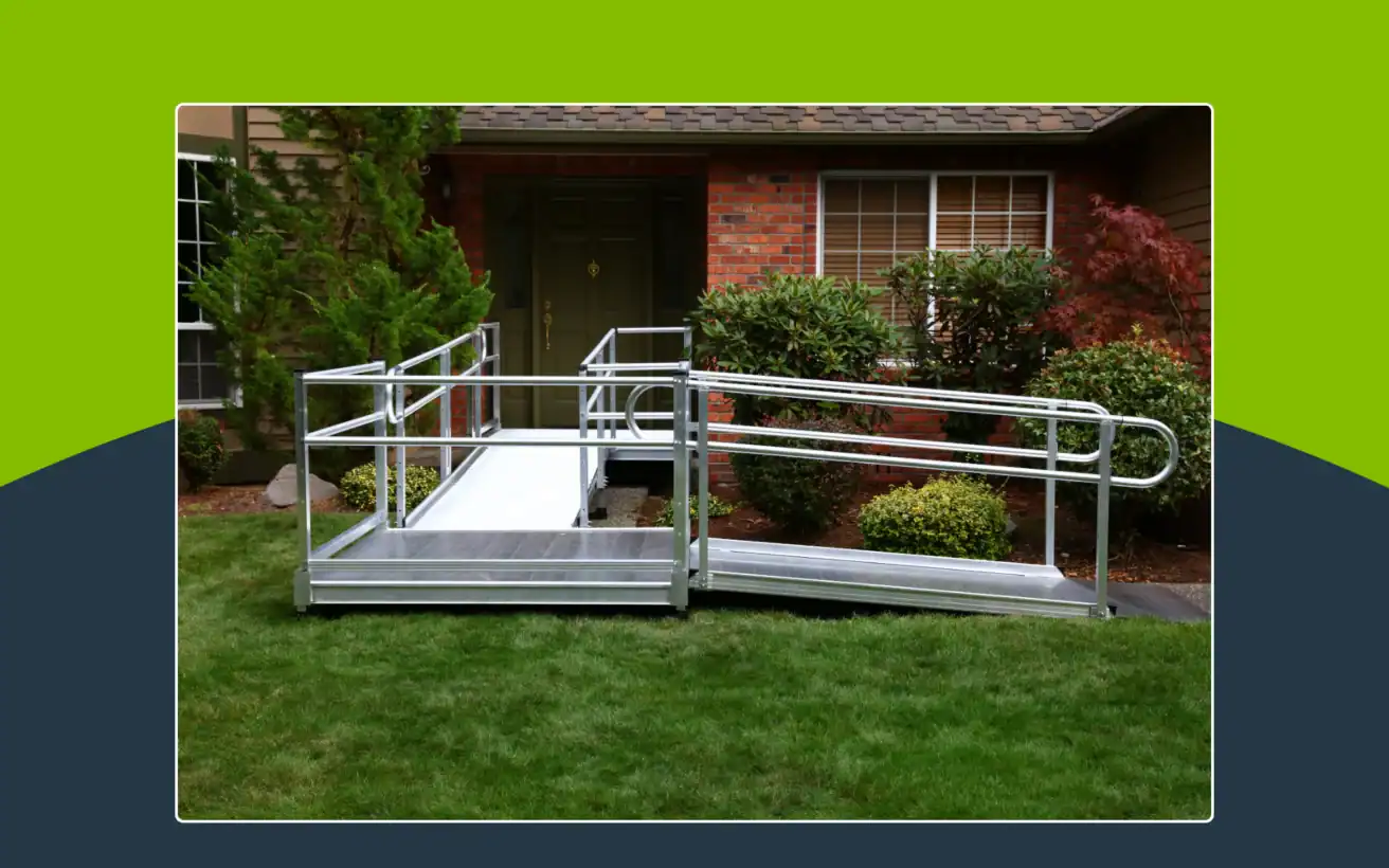 A metal wheelchair ramp is installed over a grassy yard, leading to the front door of a brick house with shrubs and trees nearby.