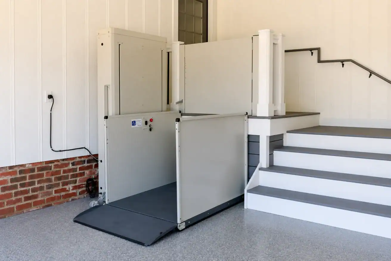 A wheelchair lift is installed next to a set of stairs, providing accessibility to a raised platform in a building’s interior.