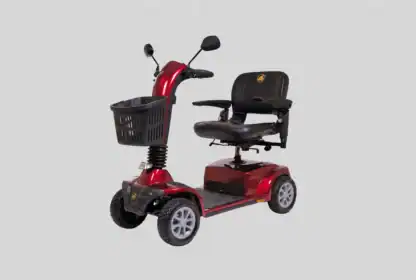 A red four-wheel mobility scooter with a black seat, basket on the front, armrests, rearview mirrors, and handlebars, shown against a plain gray background.
