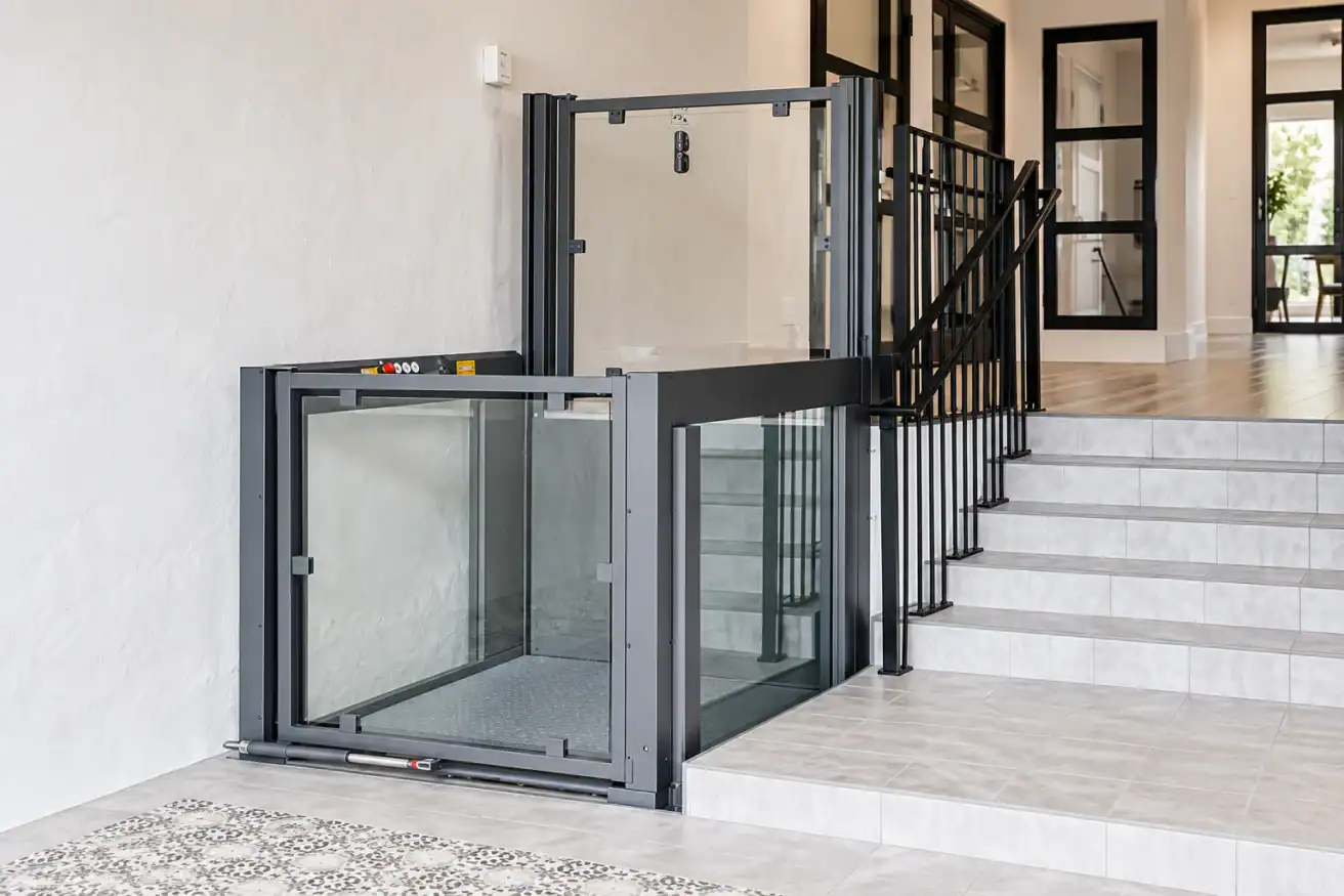A residential wheelchair lift is installed next to a staircase, providing accessible entry between two levels inside a modern home.