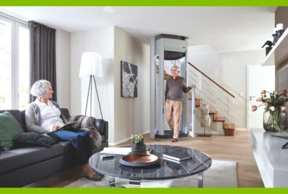 A man steps out of a residential elevator in a living room where a woman sits on a sofa.