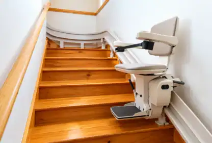 A stair lift installed on a wooden staircase.