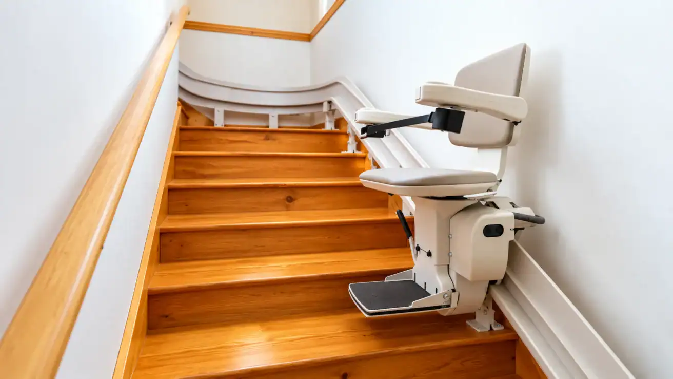 A stairlift installed on a wooden staircase.