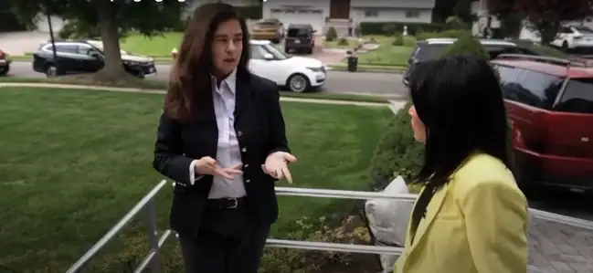 Kim Kuester and reporter in professional attire stand outside on a residential sidewalk having a conversation on the Today Show in Long Island home.